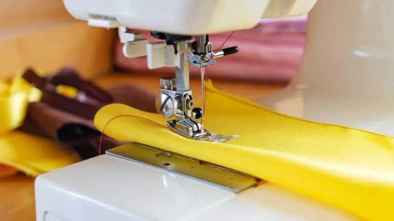 Máquina de coser trabajando sobre una tela amarilla